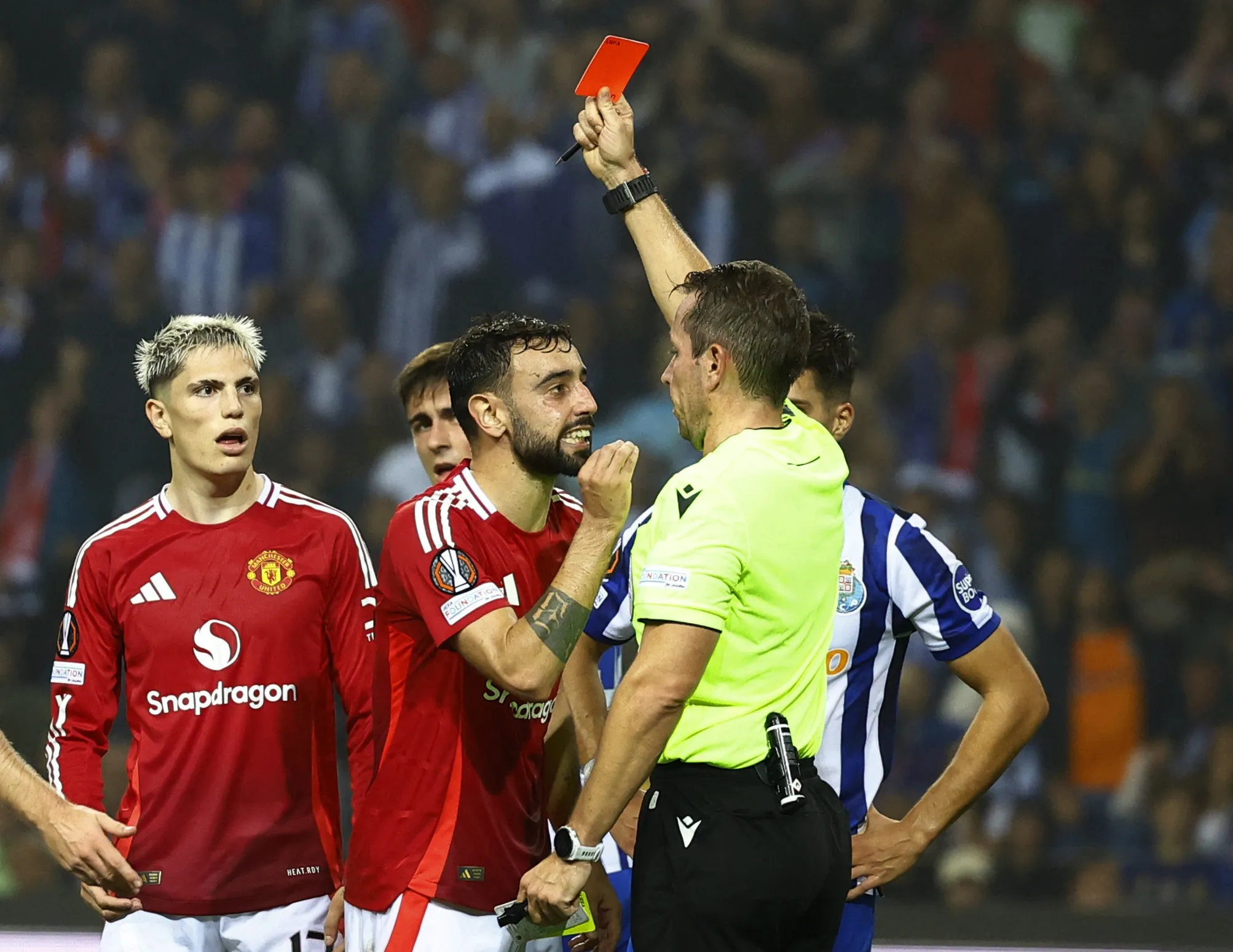 a soccer player wearing a snapdragon shirt is shown a red card