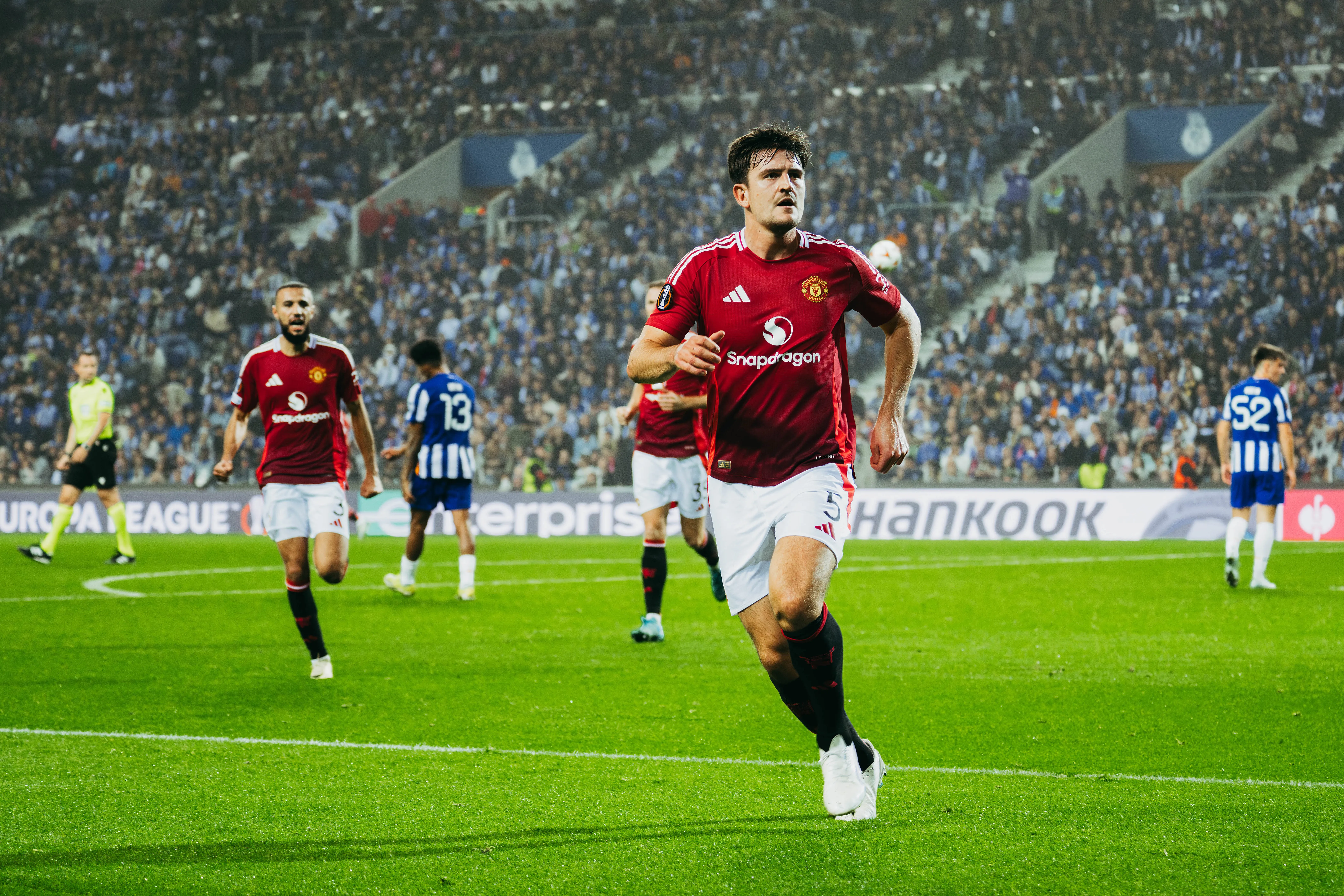 soccer players on a field with a hankook ad in the background